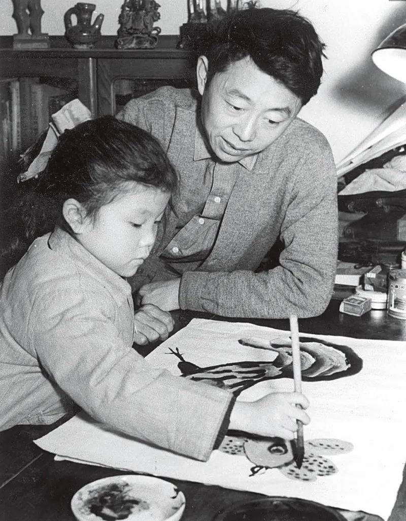 △黄永玉在指导5岁的女儿黑妮作画，1962年