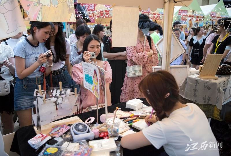 6月10日，游客们九龙湖&middot;鸿鹄大集市一网红摊位前排队等候画像。