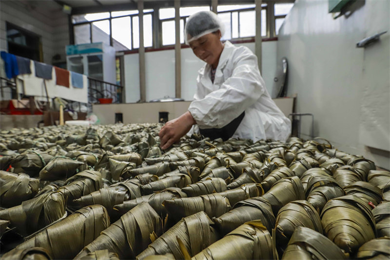 6月16日，工人在河北省迁西县东莲花院镇一家食品加工企业粽子生产车间整理检查煮熟的粽子质量。