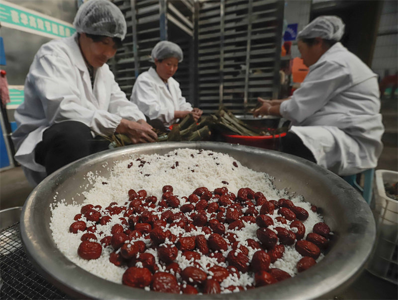 6月16日，工人在河北省迁西县东莲花院镇一家食品加工企业粽子生产车间包制传统粽子。