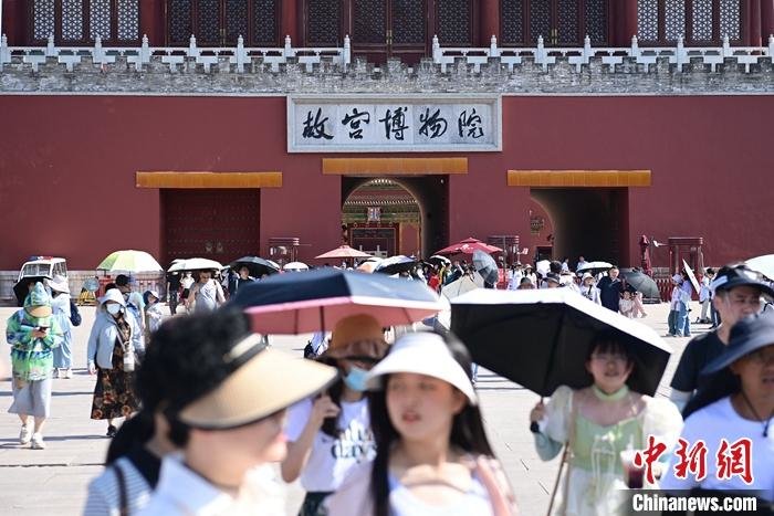 6月22日,北京故宫博物院游客撑伞、戴遮阳帽防晒。当日,北京南郊观象台录得今年首个40℃以上高温。据悉,上一次北京出现40℃以上的高温还是2014年5月29日。 中新社记者 田雨昊 摄