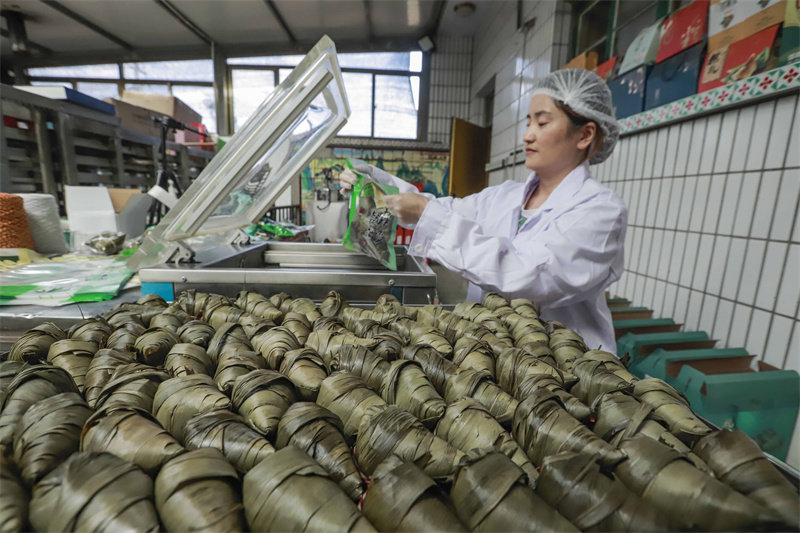6月16日，工人在河北省迁西县东莲花院镇一家食品加工企业粽子生产车间将粽子装入真空袋。