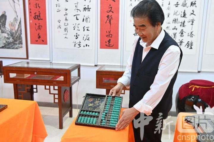6月15日，甘肃省定西市陇西县，民间收藏爱好者程万里展示收藏的老算盘。程万里今年64岁，他的家中摆满了十几年来他所收藏的近百把古董老算盘，主要以古代账房、钱庄使用的算盘为主。他说：“接下来将计划教授学生珠算，让学生感受传统珠算文化。” 中新社记者 九美旦增 摄