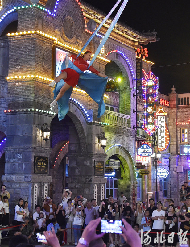 6月21日晚，游客在位于石家庄市鹿泉区的龙泉古镇景区欣赏杂技表演。