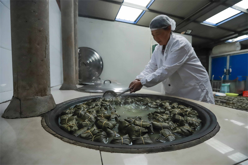 6月16日，工人在河北省迁西县东莲花院镇一家食品加工企业粽子生产车间用传统方法蒸煮粽子。