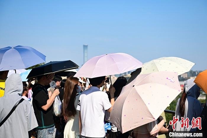 6月22日,北京故宫博物院游客撑伞、戴遮阳帽防晒。当日,北京南郊观象台录得今年首个40℃以上高温。据悉,上一次北京出现40℃以上的高温还是2014年5月29日。 中新社记者 田雨昊 摄