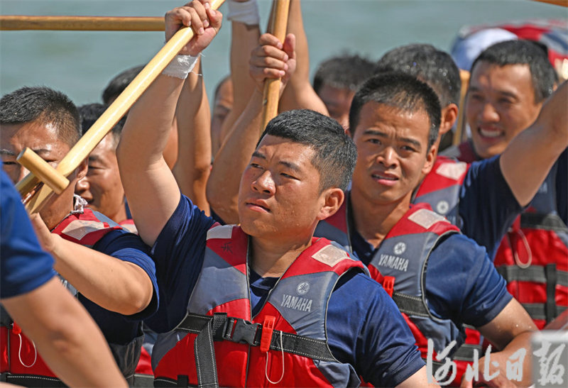 6月22日，参赛队员赛前挥动船桨为自己加油打气。