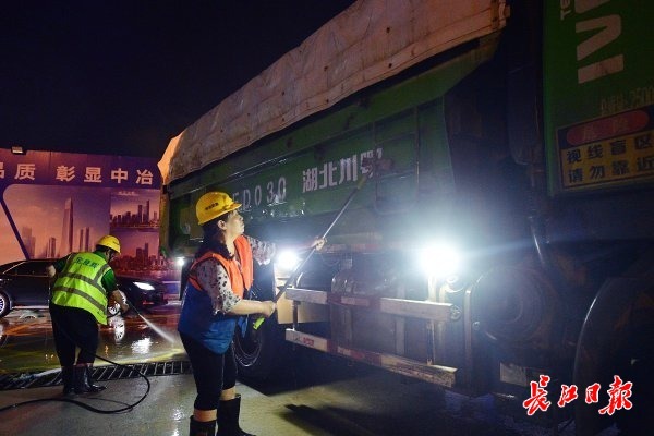 渣土车驶出工地时，由专人对车身和轮胎进行清洗。 记者李永刚 摄