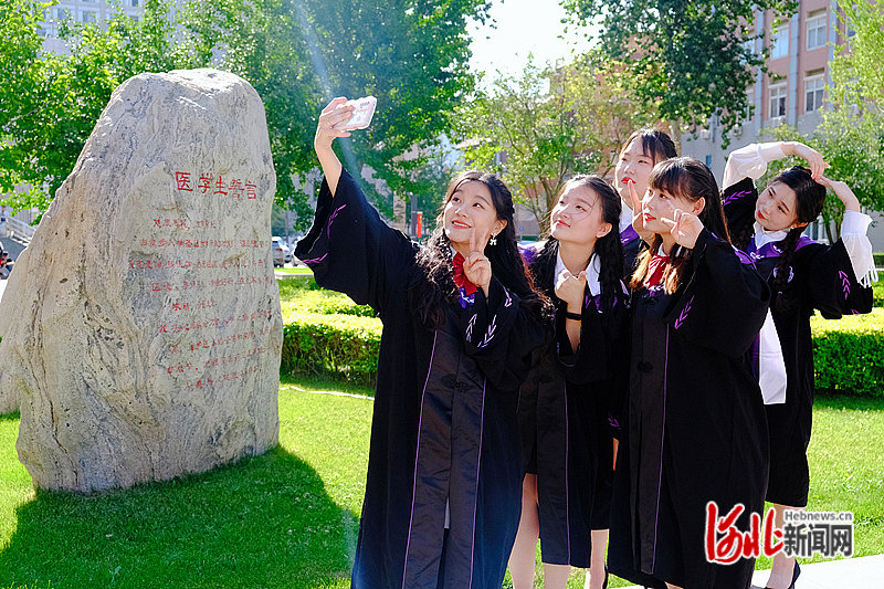 毕业来临之际，河北医科大学为同学们准备了专属学位服。图为毕业生们穿上专属学位服在校园里留下珍贵的青春纪念。河北医科大学供图