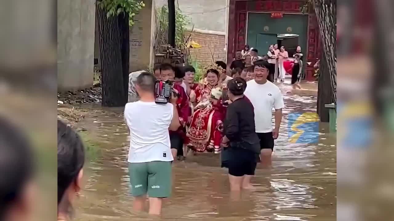 雨天积水阻碍花车，伴郎团蹚水抬新娘进门