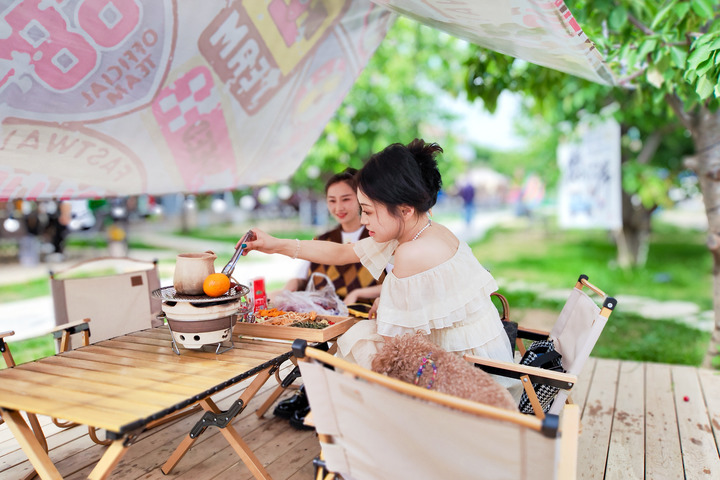 5月30日，天水市民赵思路（左）和朋友在李官湾村楠山李烧烤露营基地的天幕下围炉煮茶。新华每日电讯记者 郎兵兵 摄