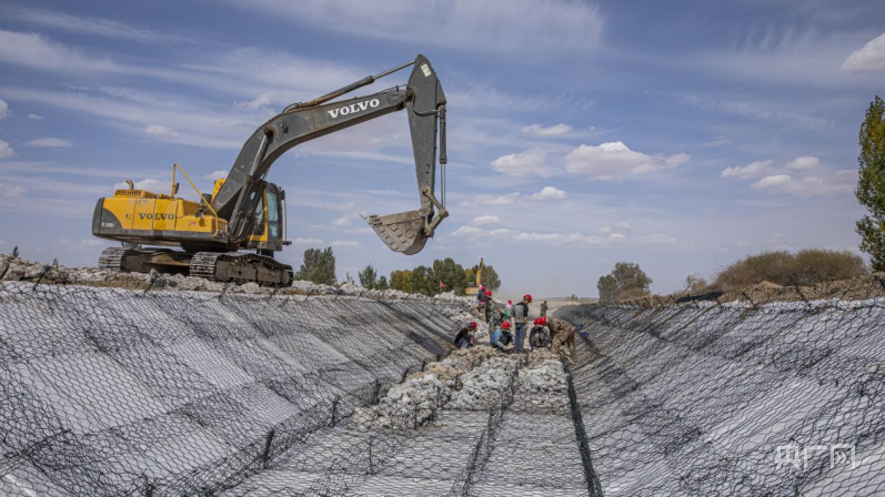 施工机械与工人师傅密切配合,进行绿滨垫衬砌作业(央广网发 高台县委宣传部 供图)