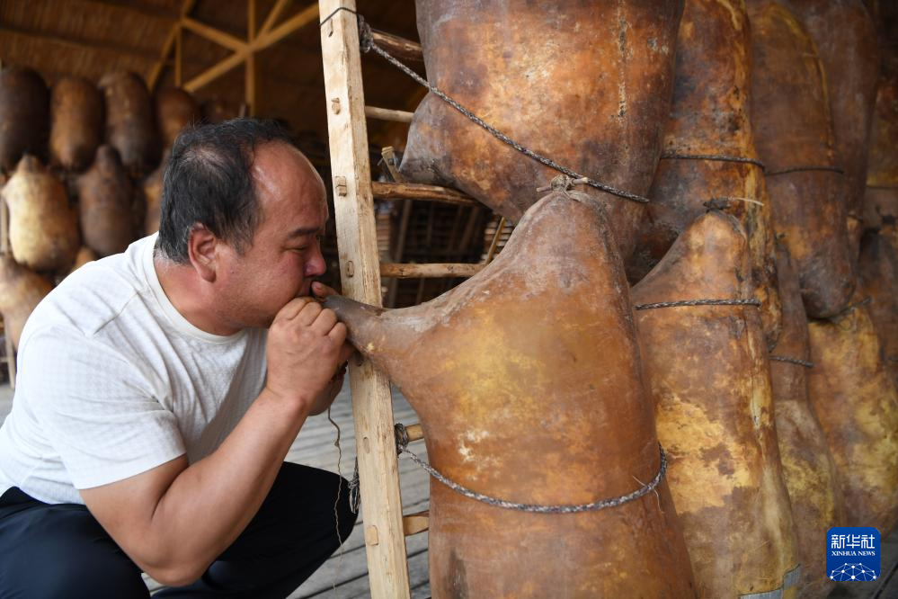 在黄河石林景区，一名筏子客对着羊皮筏子吹气准备漂流（7月11日摄）。新华社记者 张可任 摄