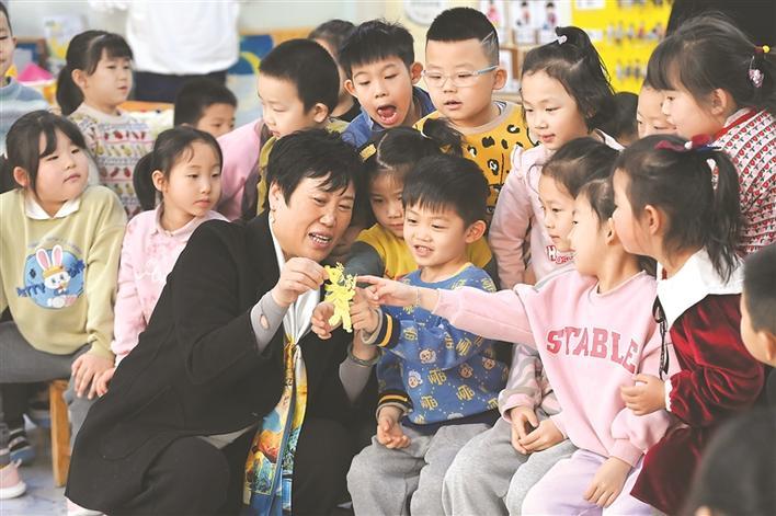 图为市级非遗传承人、临县剪纸协会会长刘小平为八一街幼儿园的小朋友传授剪纸技巧（吕梁日报记者 刘亮亮 摄）