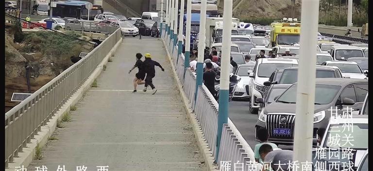 ▲外卖小哥和一名黑衣男子率先冲上前救人（图中所示为轻生女子所在位置）（现场监控视频截图）