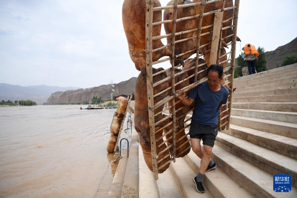 一名筏子客在黄河石林景区背着羊皮筏子准备漂流（7月11日摄） 新华社记者 陈斌 摄