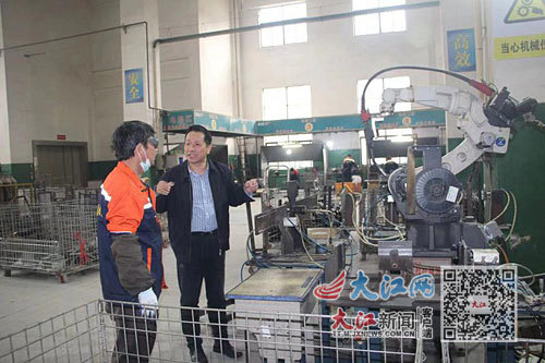 廖志良在车间和工人讨论工艺