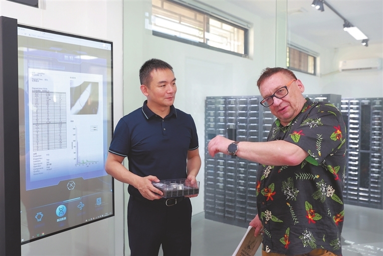 7月12日,景德镇古陶瓷基因库负责人翁彦俊(左)向来自波兰的陶瓷爱好者皮特介绍物理和数字形态的基因库标本。