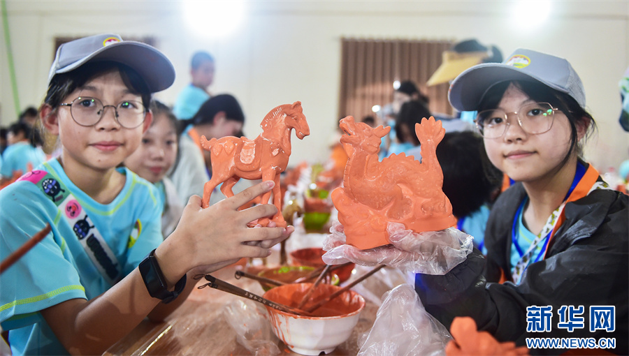 7月16日，河南洛陽市孟津區(qū)朝陽鎮(zhèn)南石山村唐三彩文化園，小學(xué)生在展示自己制作的唐三彩素胎施釉作品。