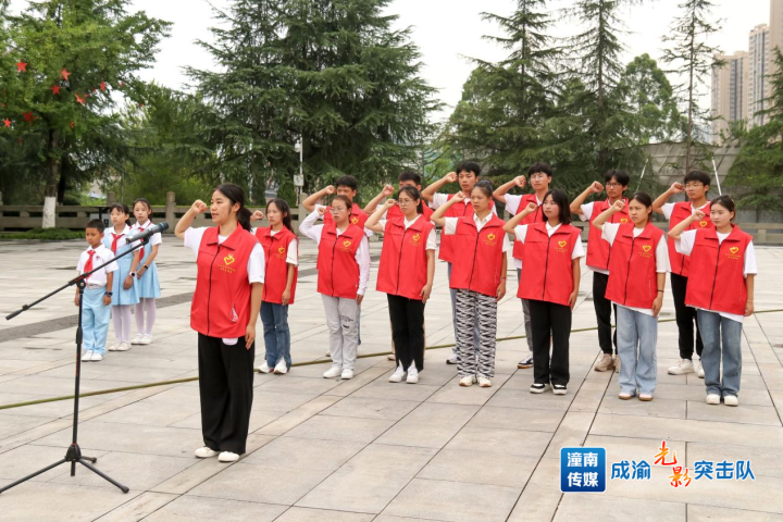 图为学生们在杨闇公烈士陵园重温入团誓词