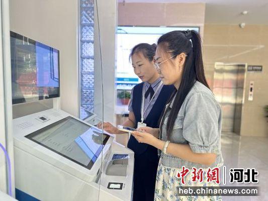 市民在路北区行政审批局“24小时自助服务区”工作人员帮助下办理业务 。