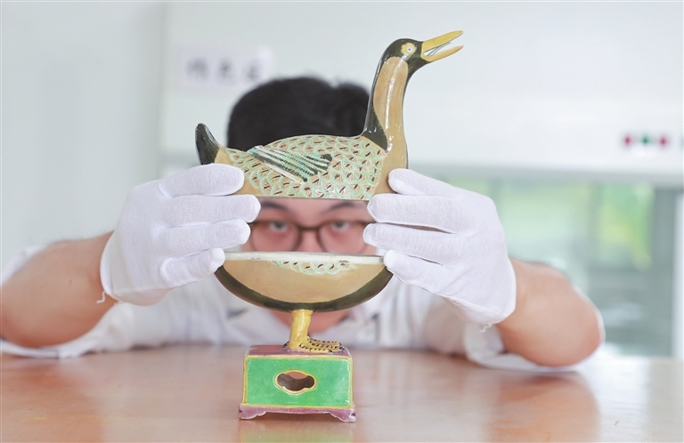 故宫博物院和景德镇古陶瓷基因库的工作人员合作,从景德镇御窑厂的陶瓷碎片中成功修复明成化年间素三彩鸭形香薰。7月13日,工作人员正在对鸭形香薰进行检查维护。