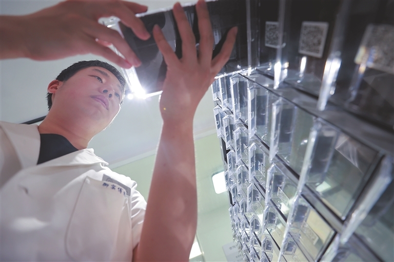 7月12日,在全球首个古陶瓷基因库——景德镇古陶瓷基因库,“长江口二号”古船中发现的清同治年间景德镇窑青花梵文折腹碗瓷片横截面标本制作完成,工作人员将标本入库。