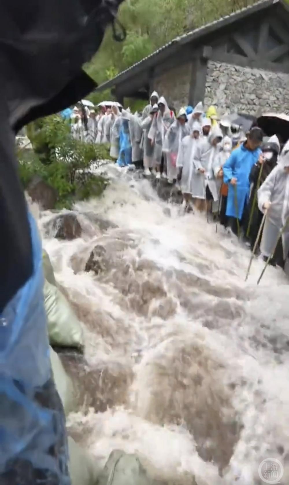 ▲暴雨后，登山路成“漂流区”。图片来源/视频截图