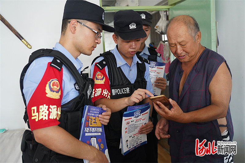 民警指导居民安装“国家反诈中心App”。