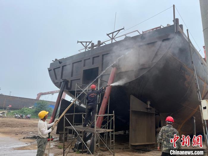 图为工人正在清洗船体。　　武海淑 摄