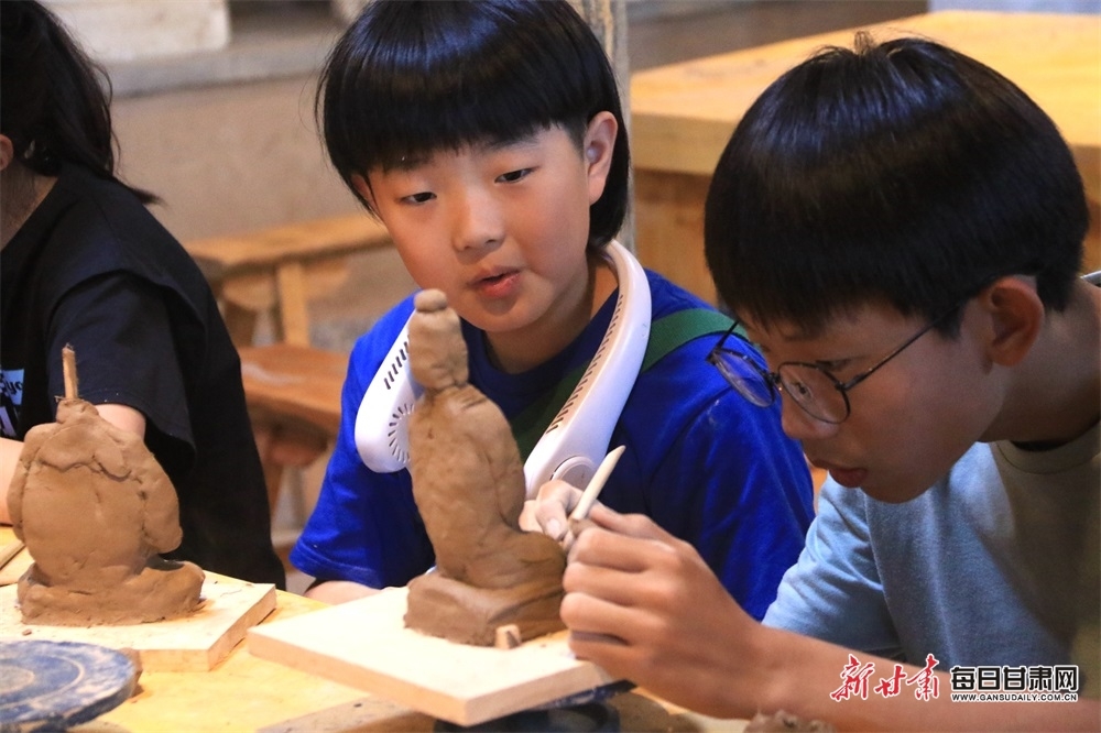 在敦煌莫高里工匠村，青少年学习制作木胎泥塑。