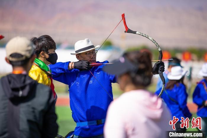 两岸记者23日在甘肃肃北草原学习并体验射箭。中新社记者李雪峰摄