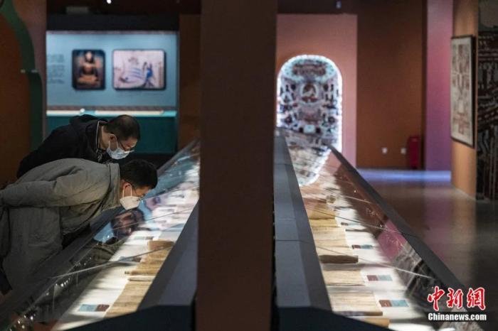 “二十世纪初中国古文献四大发现展”在位于北京的国家典籍博物馆内展出。“敦煌遗书”展区内的经文抄本展品吸引观众仔细查看。侯宇 摄