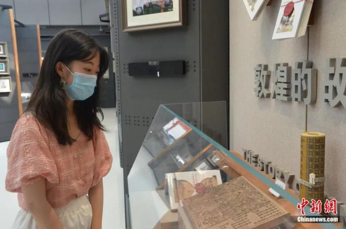 甘肃兰州，手工雕版《金刚经》首页吸引参观者。李亚龙 摄