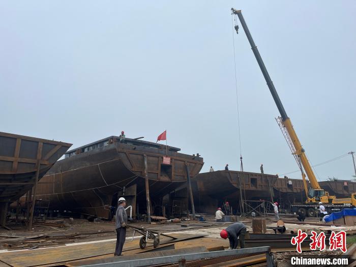 图为工人们正在加紧造船。　　武海淑 摄