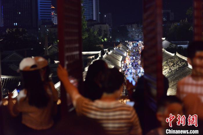 游客在烟台所城里街区欣赏夜景。曲正扬 摄