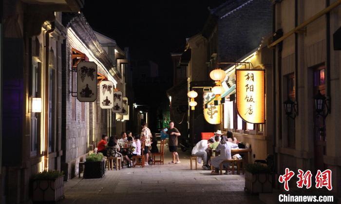 在烟台朝阳街,游客在清凉的晚风中享用美食。曲正扬 摄