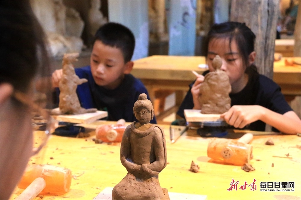 在敦煌莫高里工匠村，青少年学习制作木胎泥塑。
