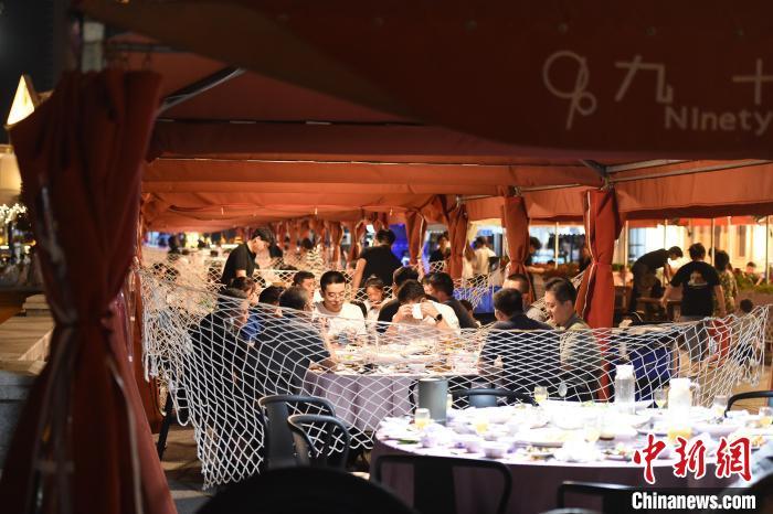 图为游客在海滨享用美食。曲正扬 摄