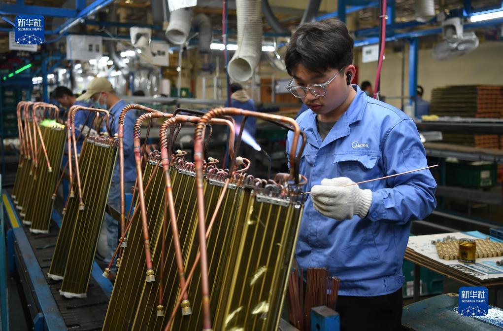 工人在美的家用空调广州工厂的生产线上工作（3月3日摄）。新华社记者 邓华 摄