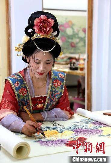 在位于山东菏泽巨野县的洪庙书画院,一位身着汉服的画师正在绘制作品。中新社记者沙见龙 摄