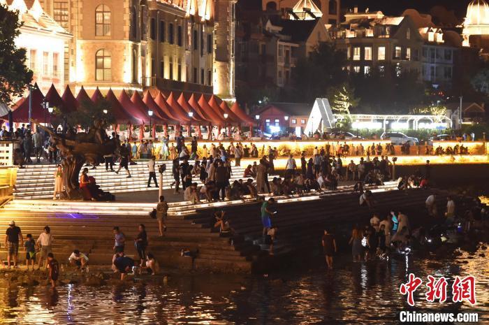 在烟台渔人码头景区,游客们在海边赶海,享受清凉。曲正扬 摄