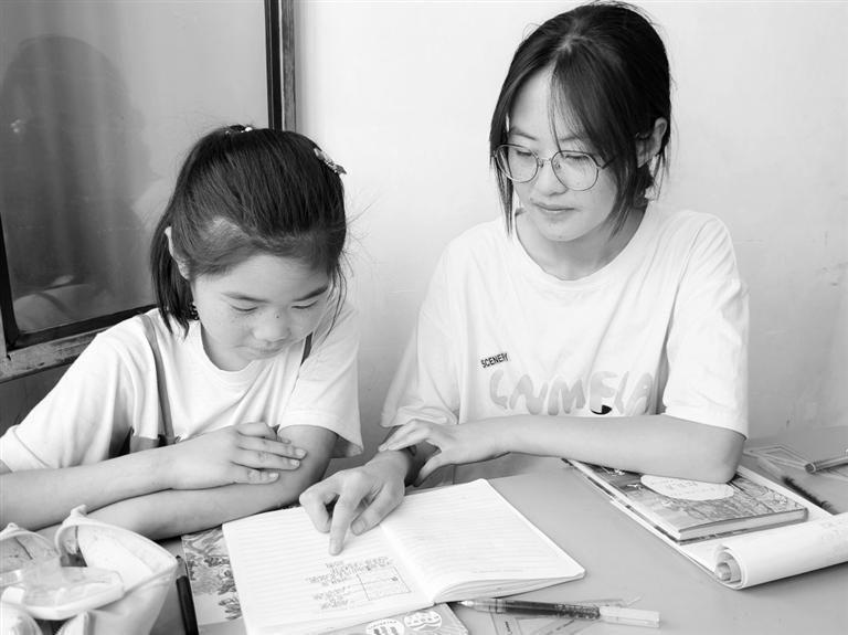 张家琴（右）为村里孩子辅导作业 受访者供图
