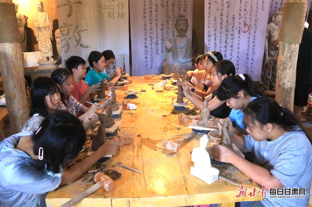 在敦煌莫高里工匠村，青少年学习制作木胎泥塑。
