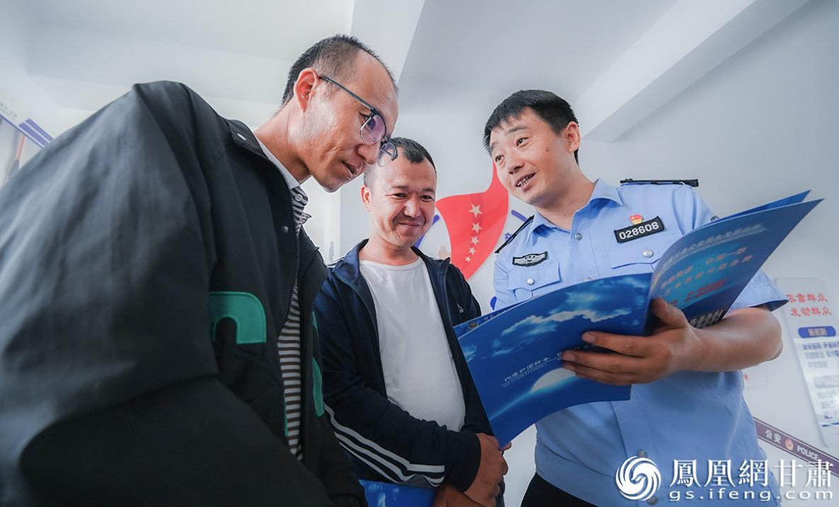 马明（右）给村民介绍保护国家野生动物的相关法律 李德宇 摄