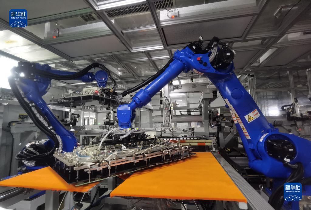 在位于青岛的海信视像智能车间的生产线上，机器人对液晶面板和背光板自动化精准卡合（6月19日摄）。新华社记者 王凯 摄