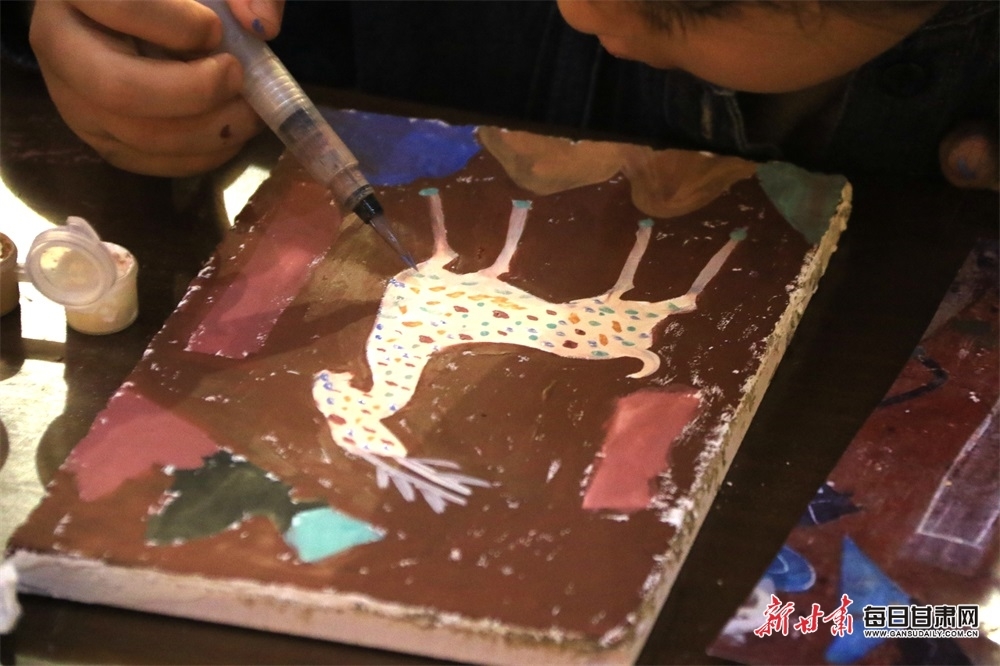 青少年在敦煌书局研学课堂上学习绘制泥版画