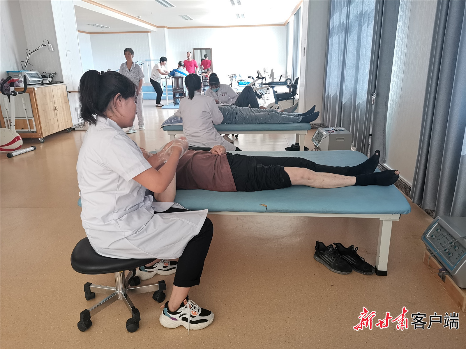 陇西县中医院智慧中医堂内，康复治疗师帮助患者进行康复训练。