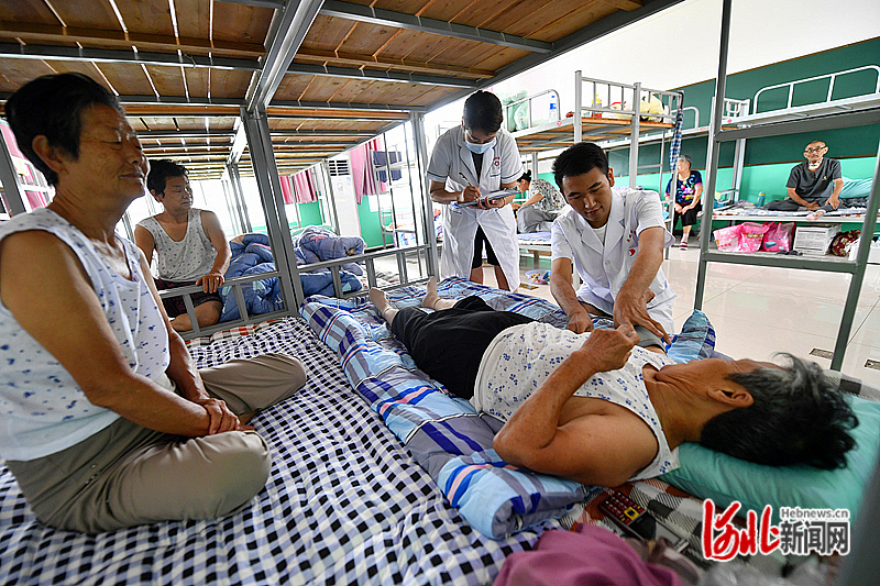 8月1日，在文安县苏桥镇中学转移群众安置点，医务工作者正在为转移群众测量血压。河北日报通讯员王晖摄