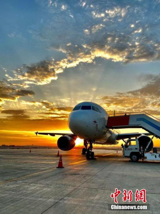 金黄色的旭日从地平线缓缓升起，橙黄色的绚烂云霞铺满天空。